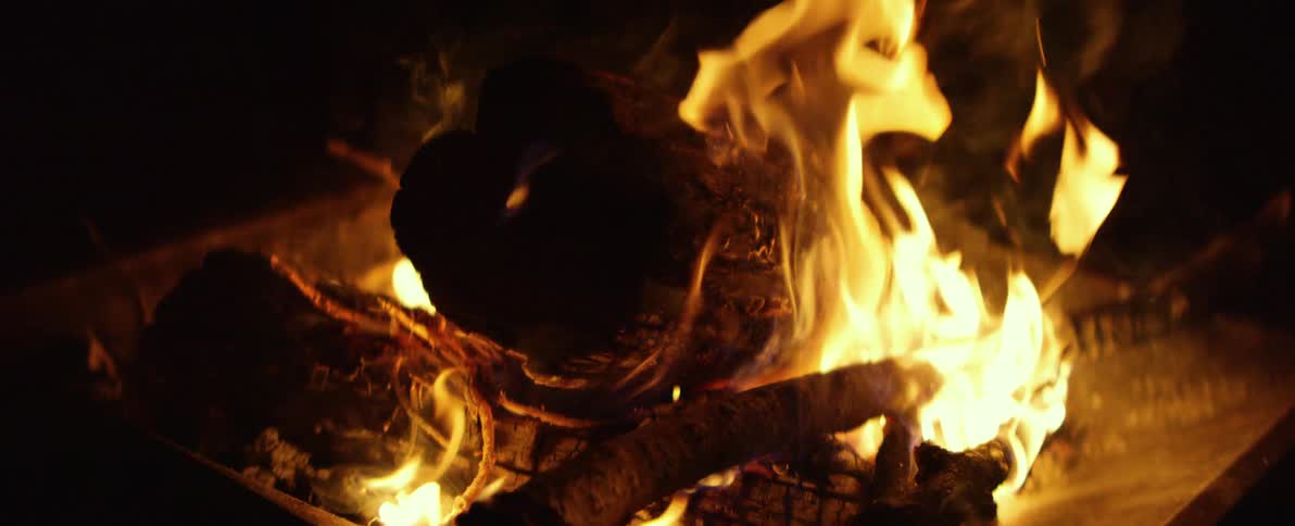 A mesmerizing slow motion close up of a crackling campfire burning at night