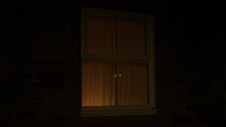 A pair of glowing eyes materializes and vanishes in a warmly lit window at night, casting an eerie and suspenseful mood
