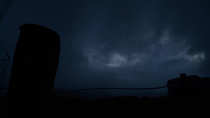 A dark and stormy night sky shows clouds moving in a moody, gloomy time-lapse
