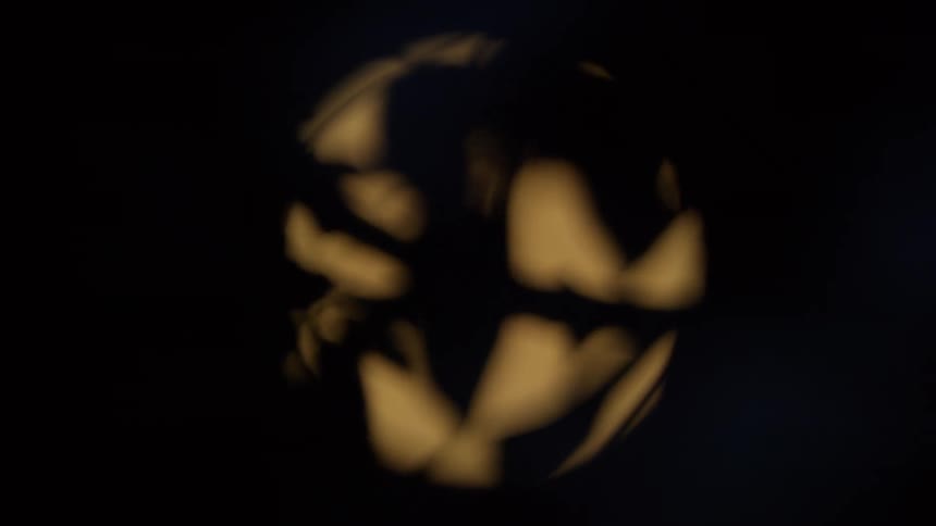 Abstract golden light refraction with slow-moving caustics inside a circle on a black background