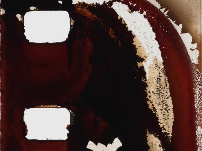 A stop-motion animation reveals the abstract textures of a burnt and decaying vintage film strip