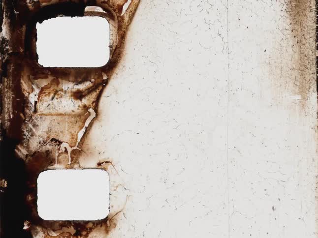 Abstract grunge background featuring a damaged and decomposing old film strip with sprocket holes
