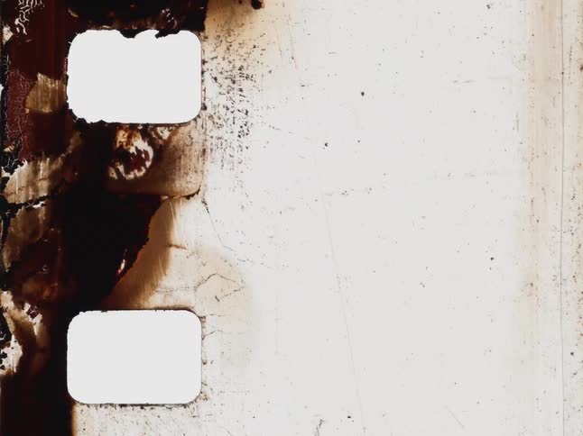 A gritty, abstract stop-motion animation shows the textured decay of a burnt and damaged vintage film strip