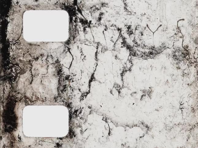 An abstract stop motion animation of a damaged vintage film strip deteriorating and decaying