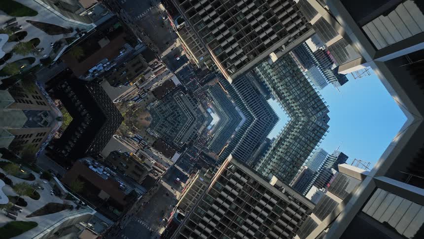 A surreal kaleidoscopic aerial view of a modern cityscape creates an abstract and disorienting visual effect