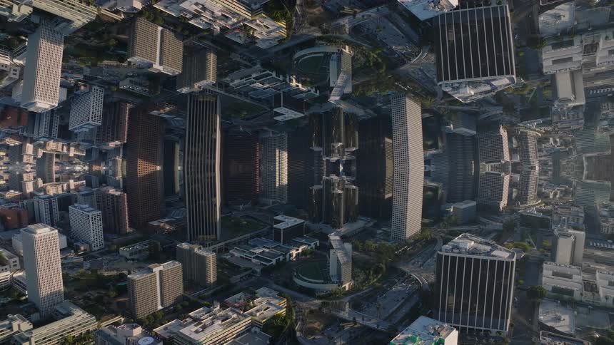 A surreal aerial time-lapse of a kaleidoscopic city with mirrored skyscrapers creating a dreamlike, disorienting visual effect