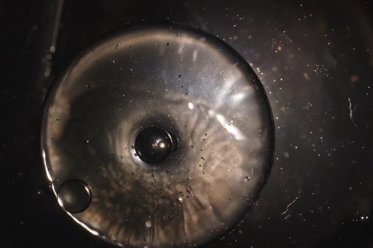 Abstract slow-motion top-down shot of a viscous liquid creating a mysterious swirling vortex