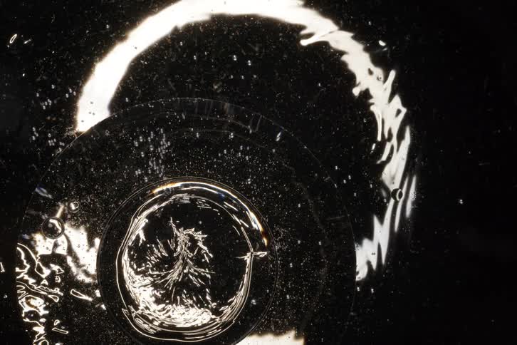 A dramatic macro view of a swirling water vortex draining away against a black background