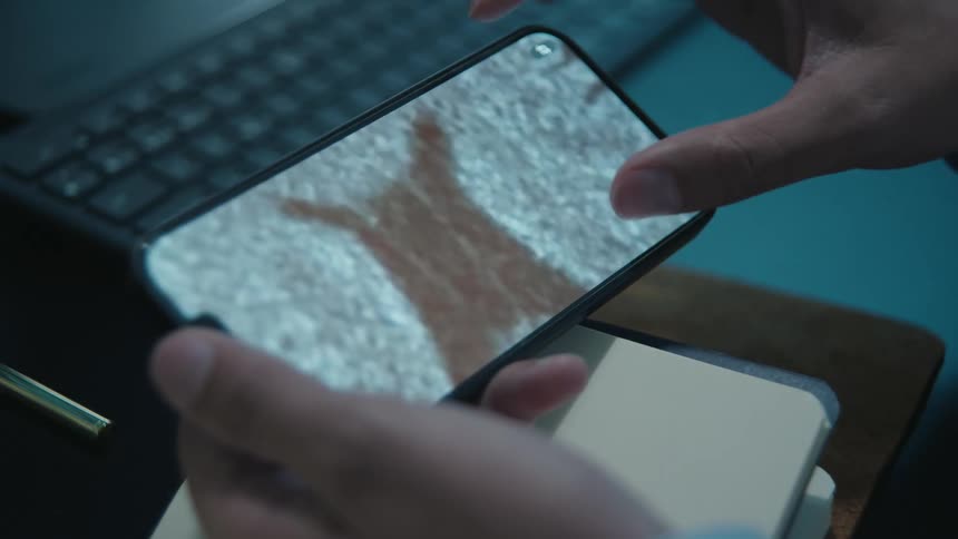 A close-up of a doctor analyzing a CT scan of a human brain on a smartphone in an office