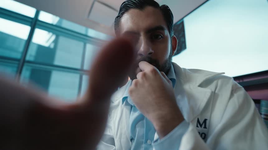 Cinemagraph from a patient's POV of a thoughtful doctor in a lab coat during a medical examination