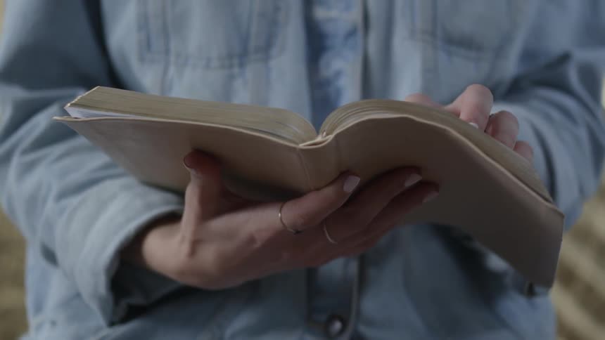 A woman holds an opened book in her hands