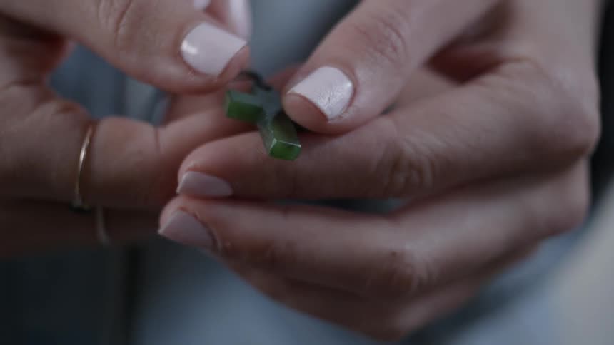 A green cross is in the person's hands