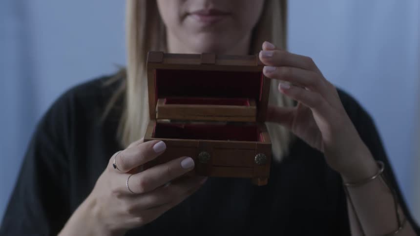 A woman opens a small chest
