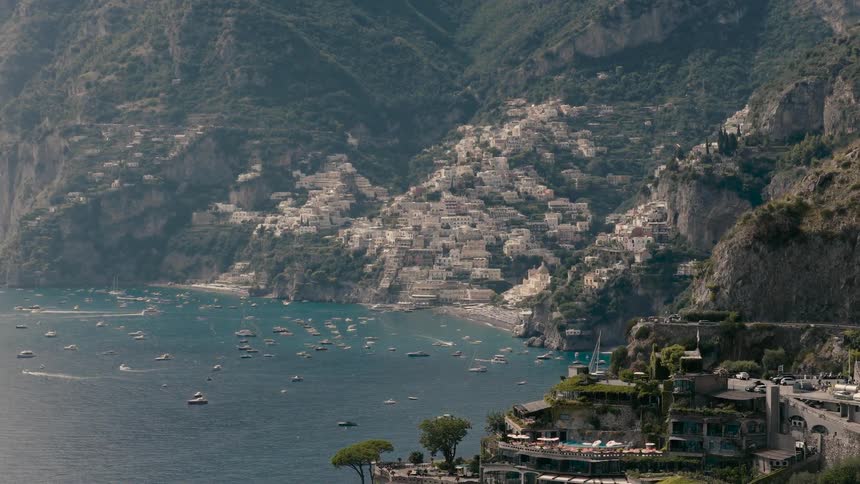Stunning aerial shot slowly pulls back to reveal the beautiful Italian coastal town of Positano with luxury resorts on the cliff