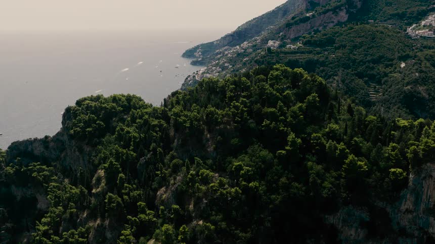 An epic aerial shot reveals the beautiful coastal town of Positano nestled along Italy's stunning Amalfi Coast