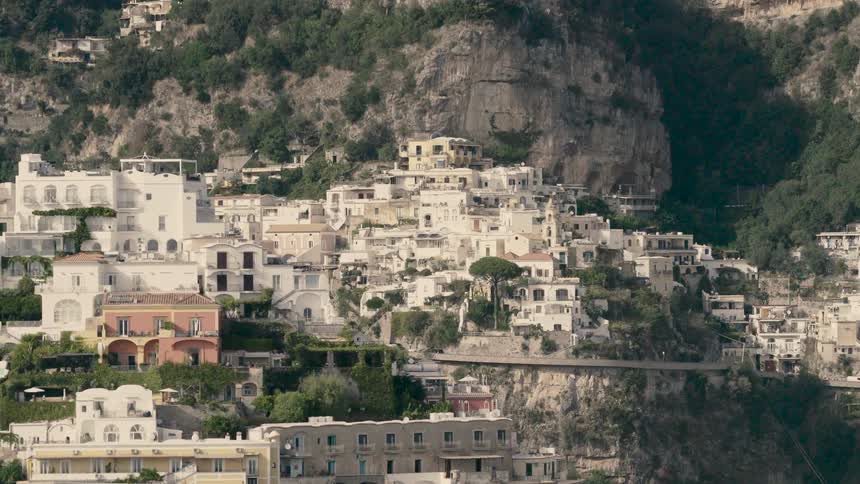 A sunny timelapse captures light and shadows moving across the iconic cliffside village of Positano on the Amalfi Coast in Italy