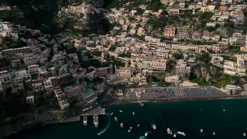 A slow pulling back aerial view reveals the iconic cliffside village of Positano on the Amalfi Coast, Italy