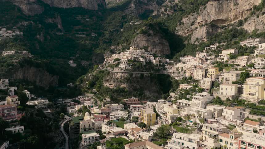 A beautiful wide aerial shot slowly pulls back revealing the picturesque cliffside village of Positano on the Amalfi Coast in Italy