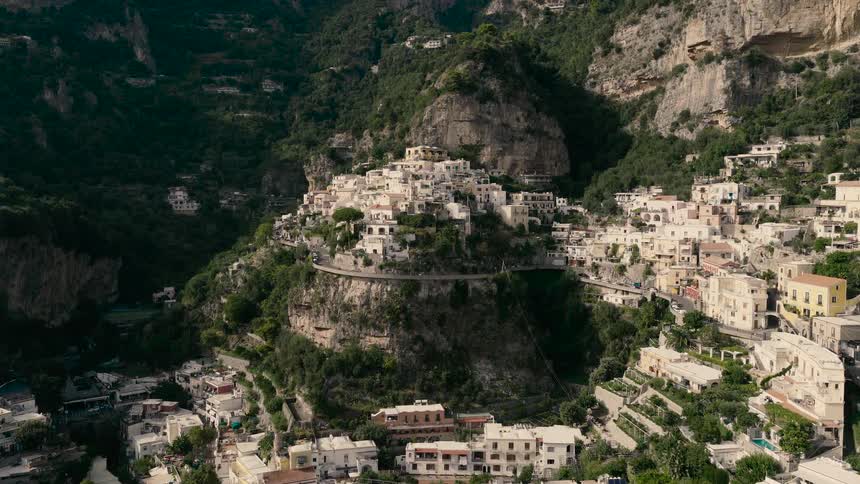 Slow aerial push-in shot of the iconic cliffside village of Positano on the stunning Amalfi Coast in Italy