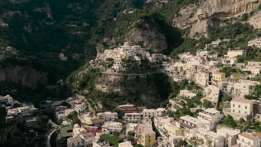 Aerial drone footage pulls back to reveal the beautiful town of Positano, nestled in the cliffs of the Amalfi Coast, Italy