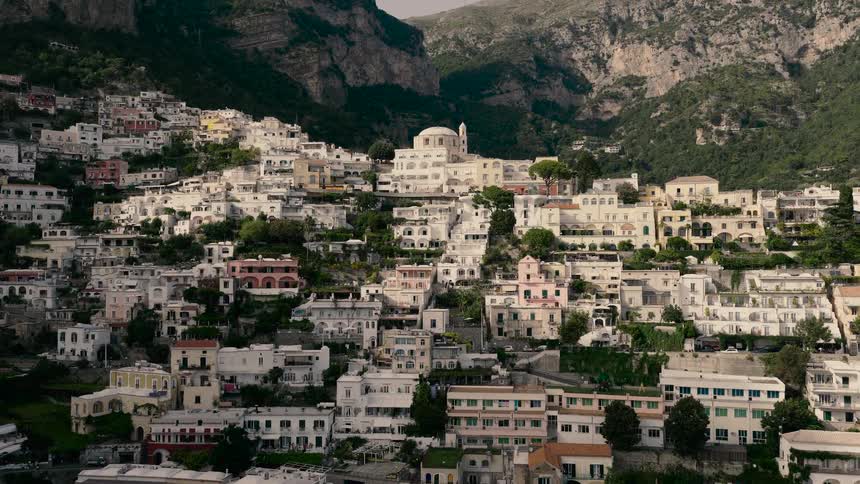 A slow aerial push-in reveals the iconic and beautiful hillside architecture of Positano on the Amalfi Coast, Italy
