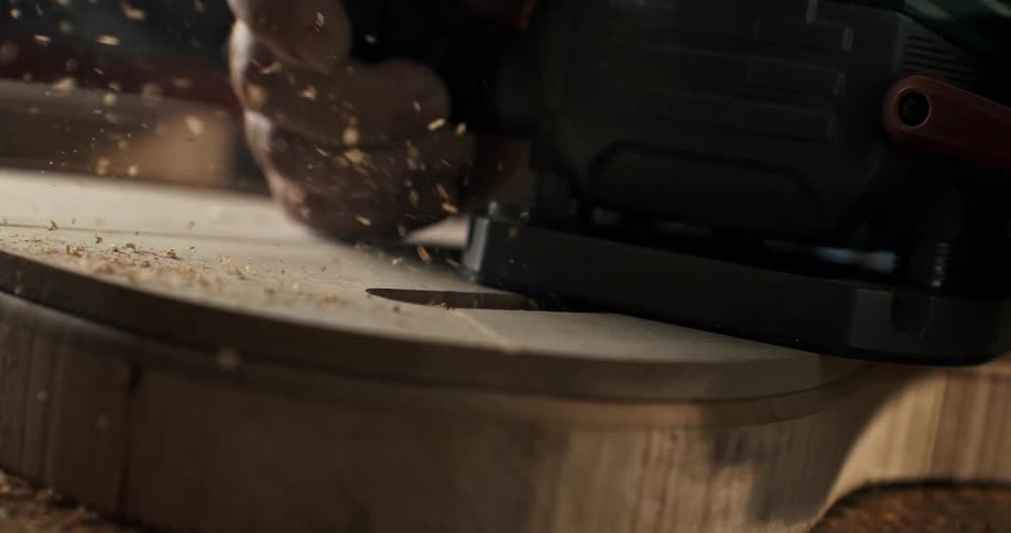 Super slow motion macro shot of a wood router cutting into a piece of timber in a workshop