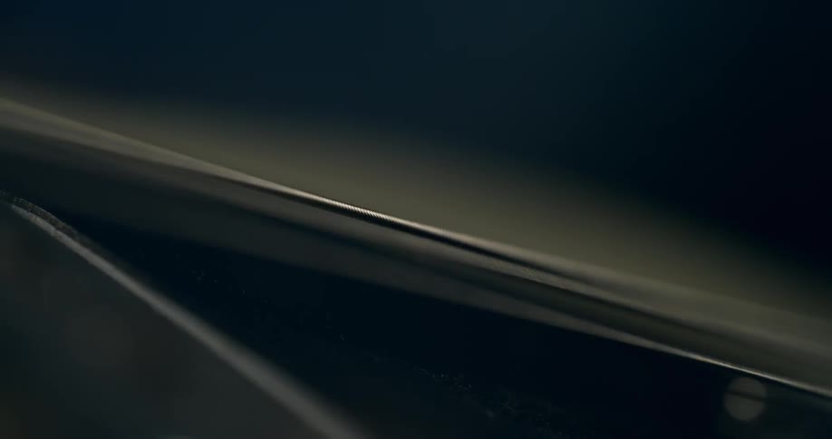A detailed macro shot shows a cello string vibrating after being plucked or bowed