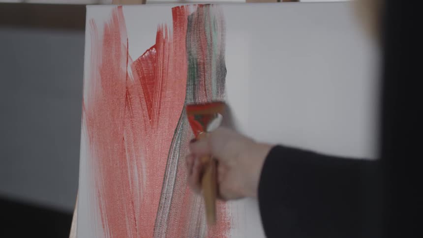 A person is painting with red and green paint