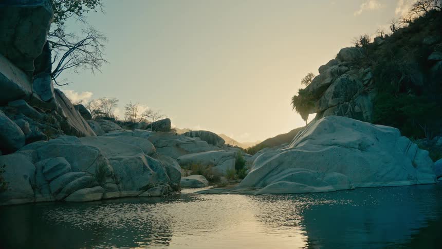 A beautiful, tranquil view of a rocky gorge with a serene pool of water at sunset