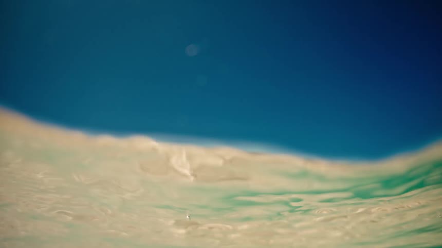 An abstract, dream-like underwater perspective captures gentle ocean waves rippling in slow motion