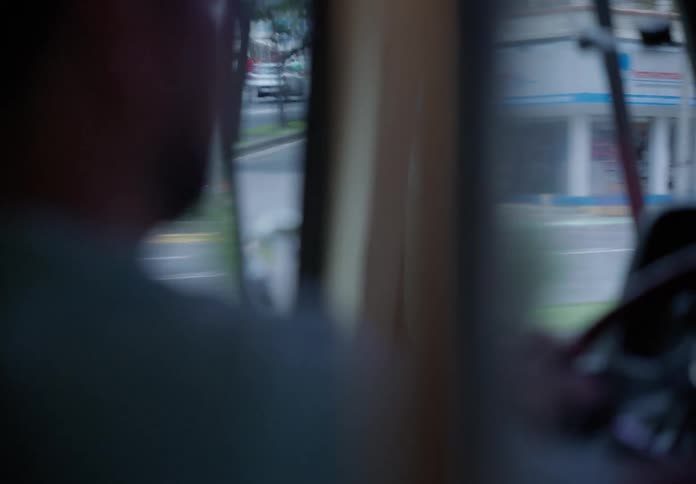 Dreamy, out-of-focus shot from inside a moving vehicle as the camera slowly focuses on the city traffic ahead