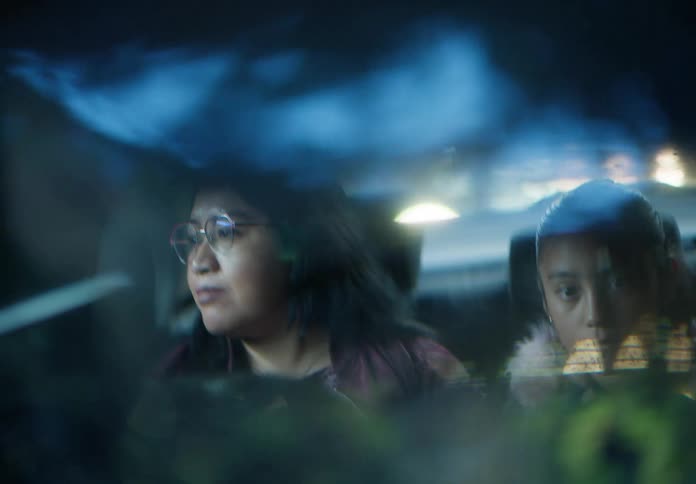 Artistic rearview mirror reflection of a mother driving her sleepy daughter home late at night