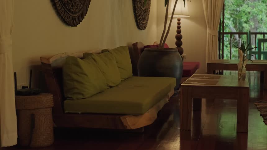 A static shot of a serene living room with natural wooden furniture and warm ambient lighting