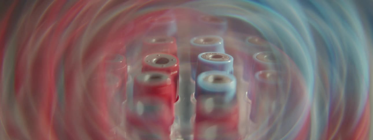 Blood sample tubes spin in a medical centrifuge, creating a mesmerizing, colorful swirl