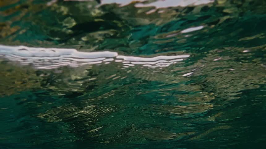 An abstract, mesmerizing view from below the ocean's surface as gentle waves ripple in slow motion