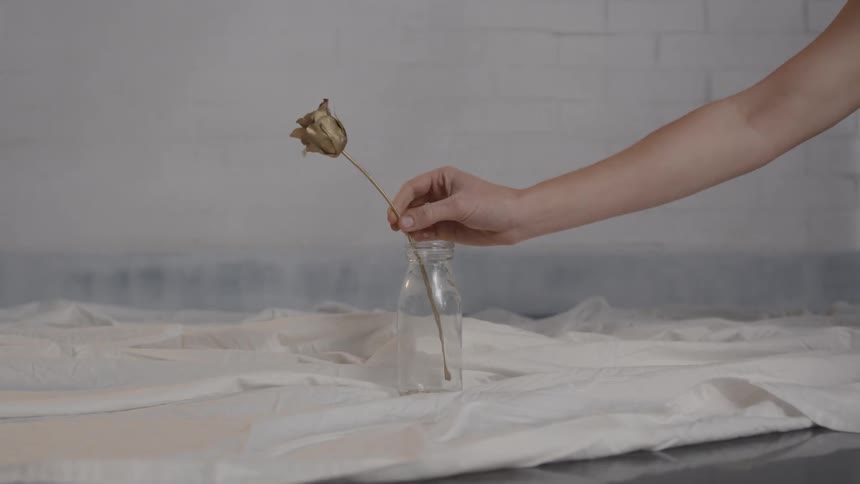 A single gold flower is put in a vase