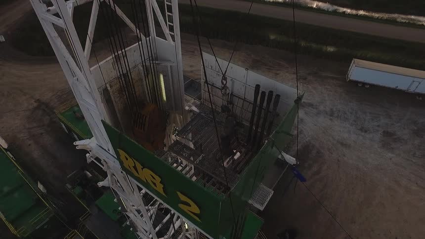 A man is standing on a platform working a machine