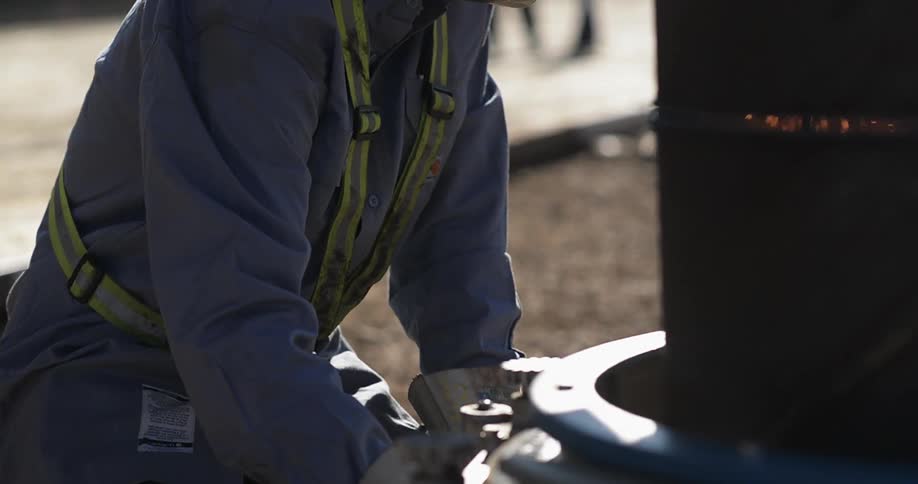 A worker is turning a tool on a site