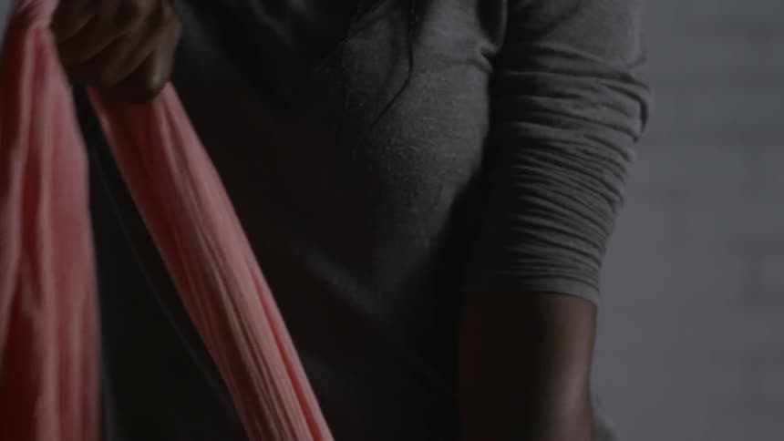 Woman pulls a pink scarf