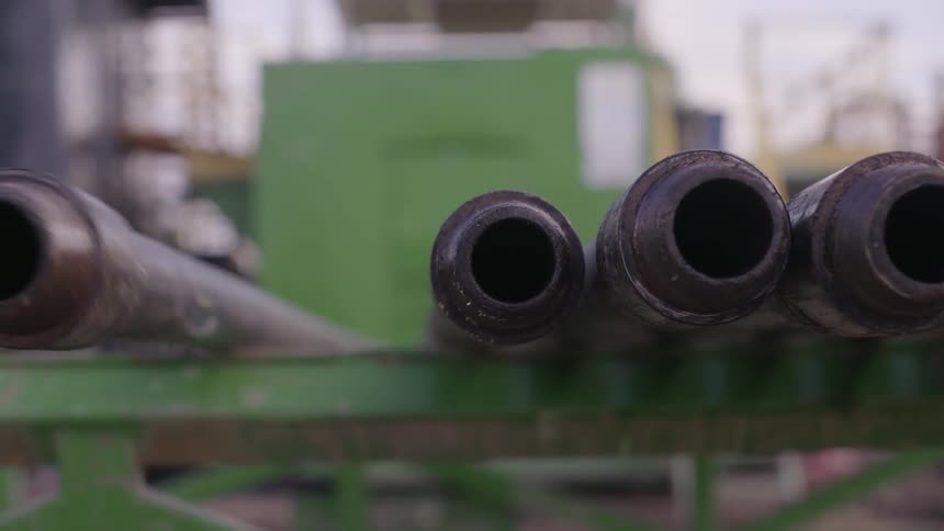 A metal pipe rolls along a beam