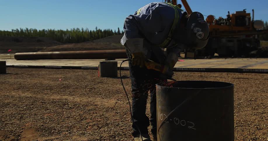 Sparks are flying as the man cuts with a saw
