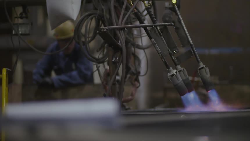 A machine is torching a piece of metal