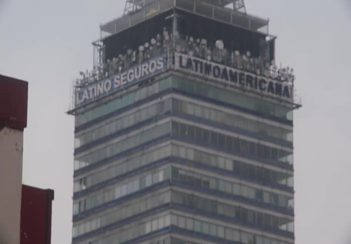 A view from the street tilting up to reveal the iconic Torre Latinoamericana skyscraper in Mexico City