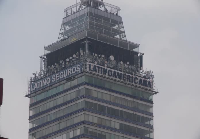 A fast pan reveals the top of the iconic Torre Latinoamericana skyscraper in Mexico City on a cloudy day