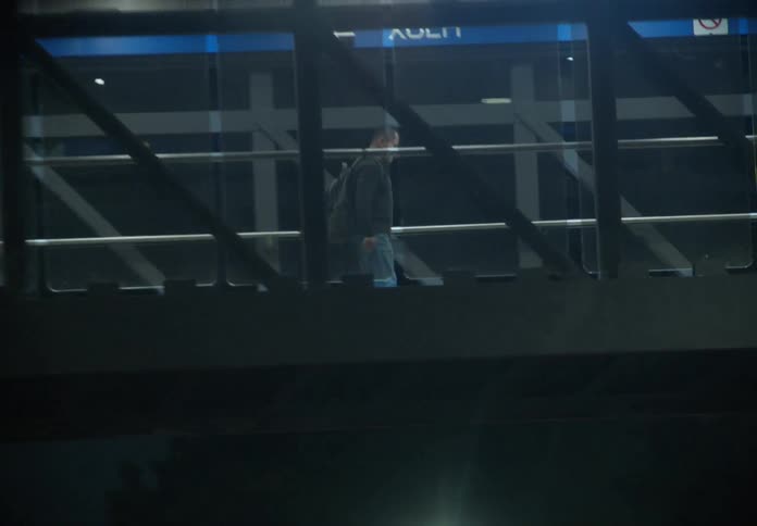 Pedestrians walk across the brightly lit overpass bridge for the Xola metro station in Mexico City at night