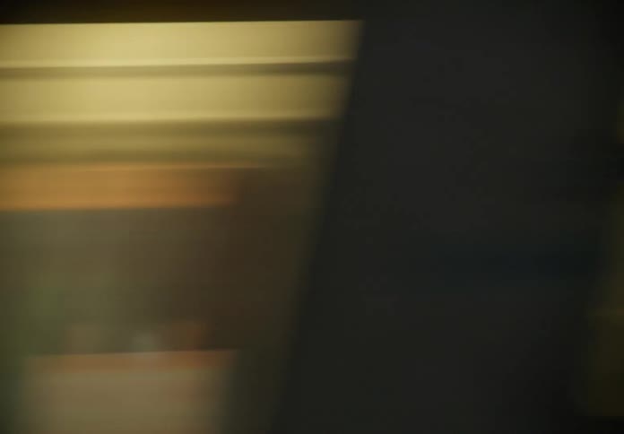 Abstract motion blur of a passing subway train at night from a moving passenger's perspective