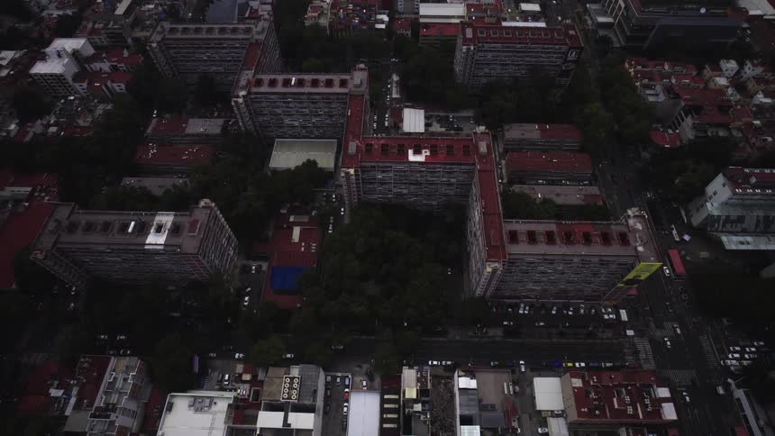 Slow aerial pull up reveals a massive urban apartment complex on a gloomy overcast day