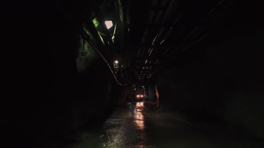 Car driving down a dark tunnel