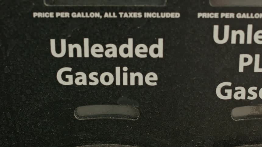 A close up on a digital gas pump displays the price of unleaded gasoline