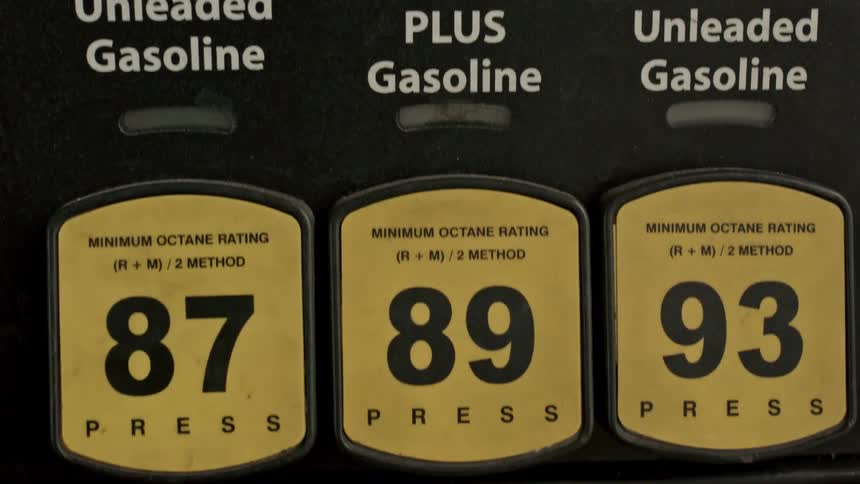 Gasoline prices for different octane ratings are displayed on a gas pump, tilting down to the selection buttons